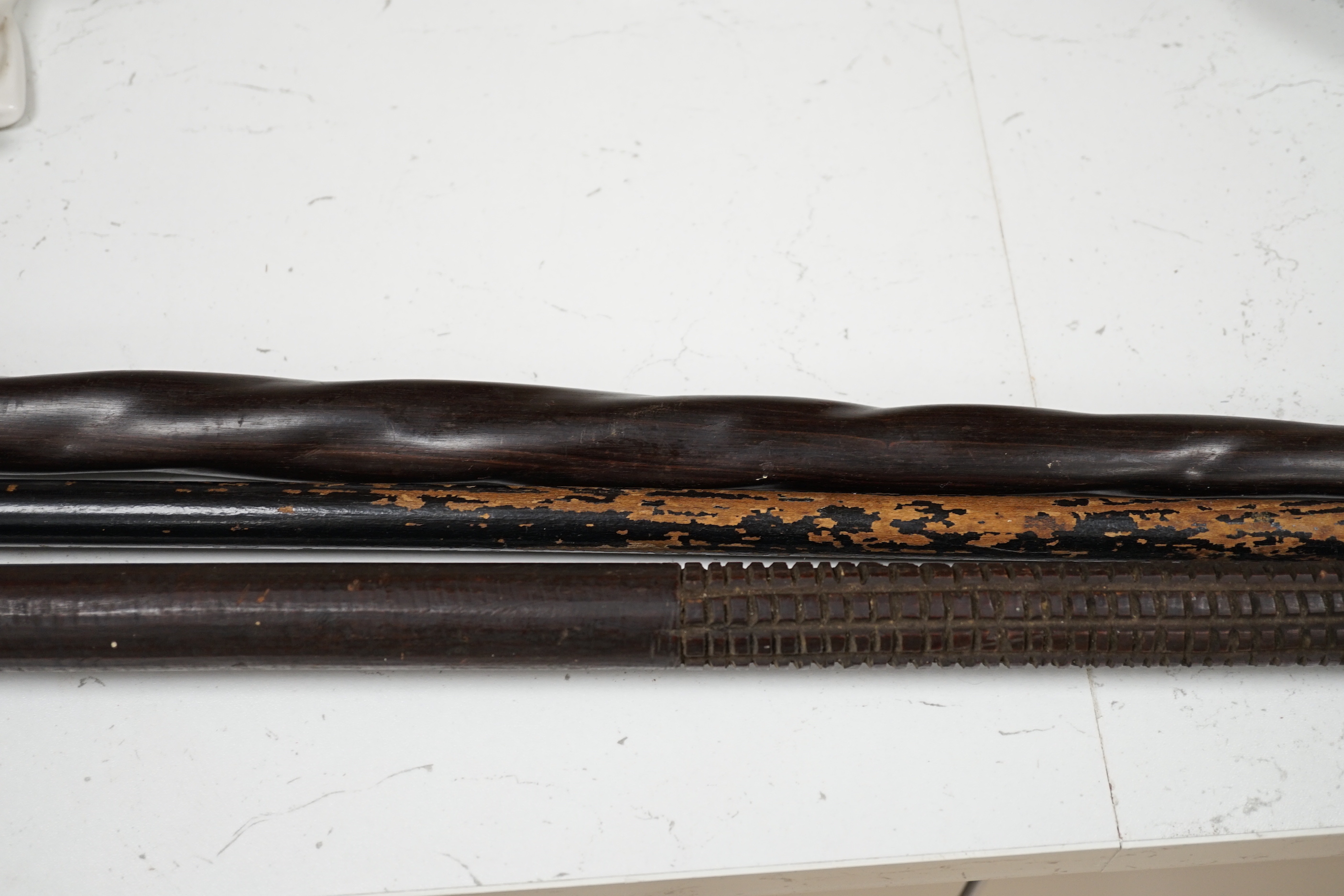 A silver topped walking cane and two African carved wood canes